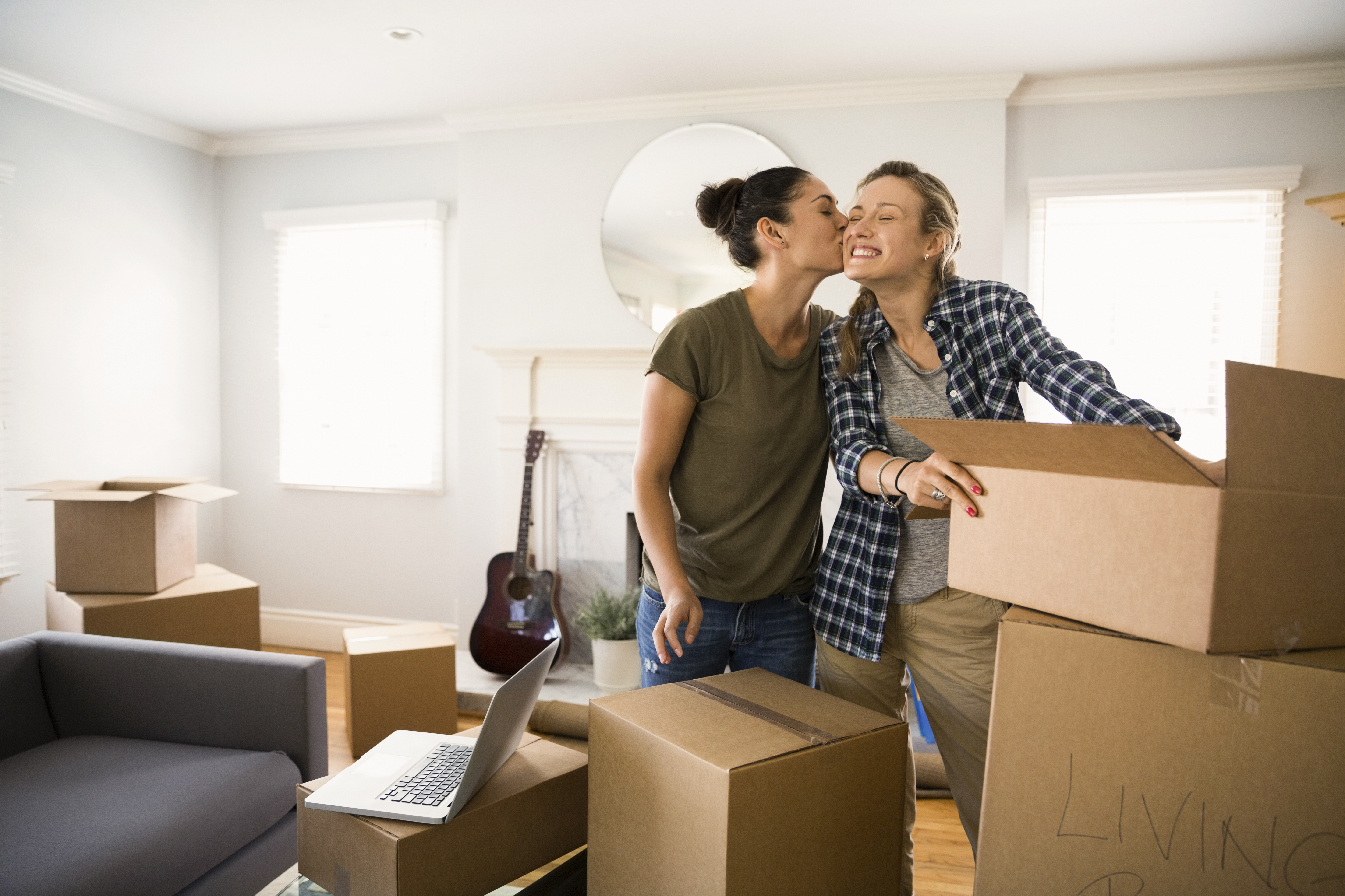 Kvinnligt par i ett rum med många flyttlådor